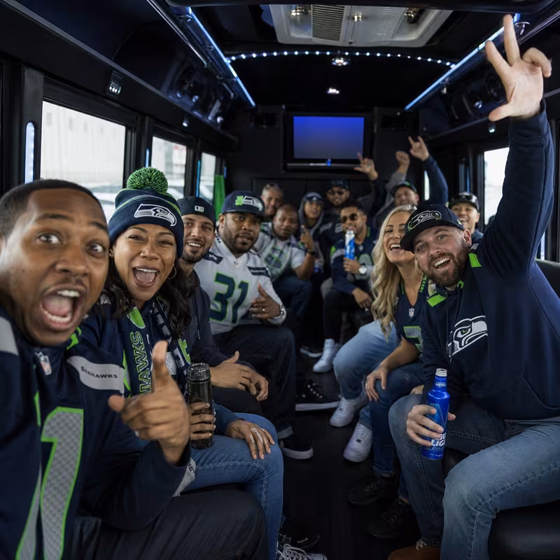 Group boarding a white charter bus for Sporting Event Transportation transportation in Seattle